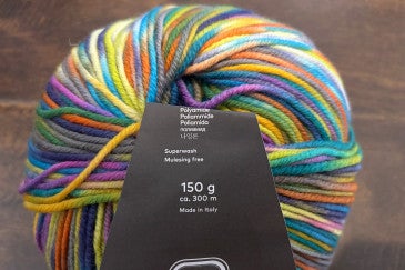 Ball of rainbow yarn with a mulesing free label