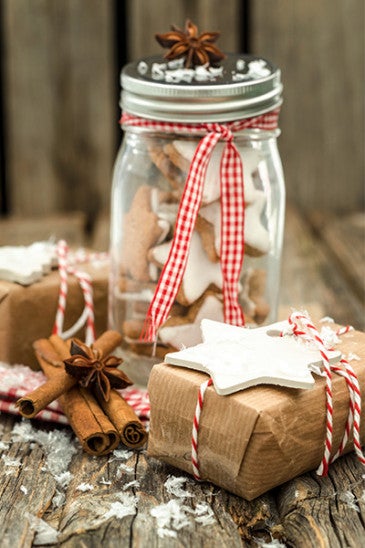 Photo of a preserving jar of home-baked cinnamon star cookies and Christmas presents.