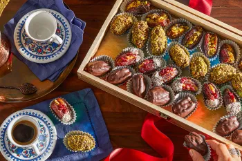 Photo from above of vegan stuffed dates displayed in a wooden box.