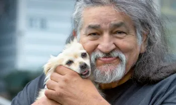 A man holds his dog at HSUS’s Rural Area Veterinary Services (RAVS) program, Taholah, Quinault Nation, WA.