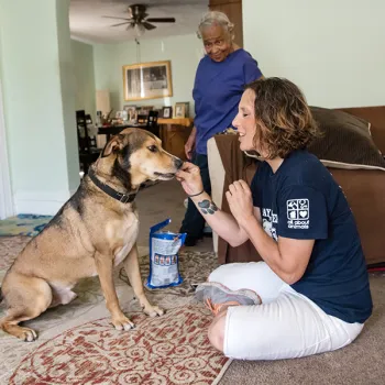 Pets for Life staff visiting a client and dog, Toby